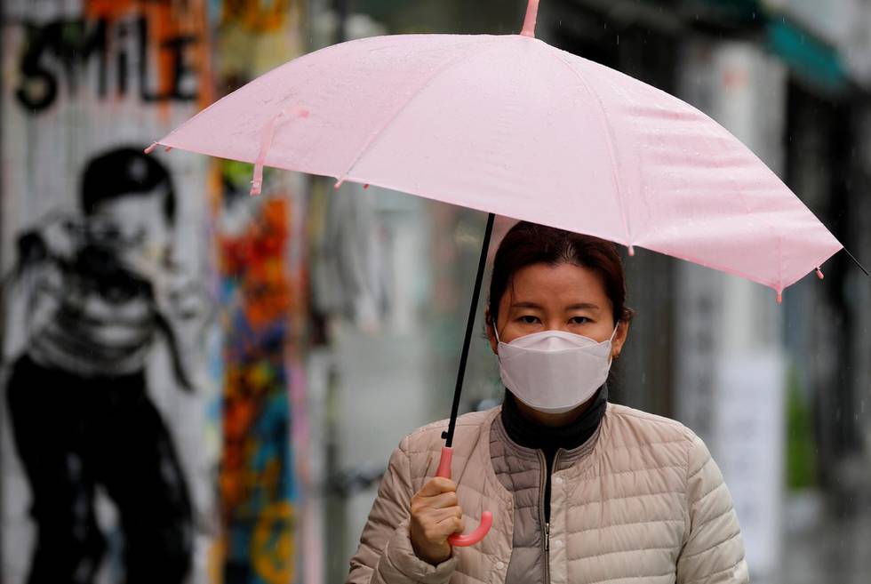 A woman, wearing a protective face mask following an outbreak of the coronavirus disease (COVID-19), makes her way downtown Daegu, South Korea, March 10, 2020. REUTERS/Kim Kyung-Hoon