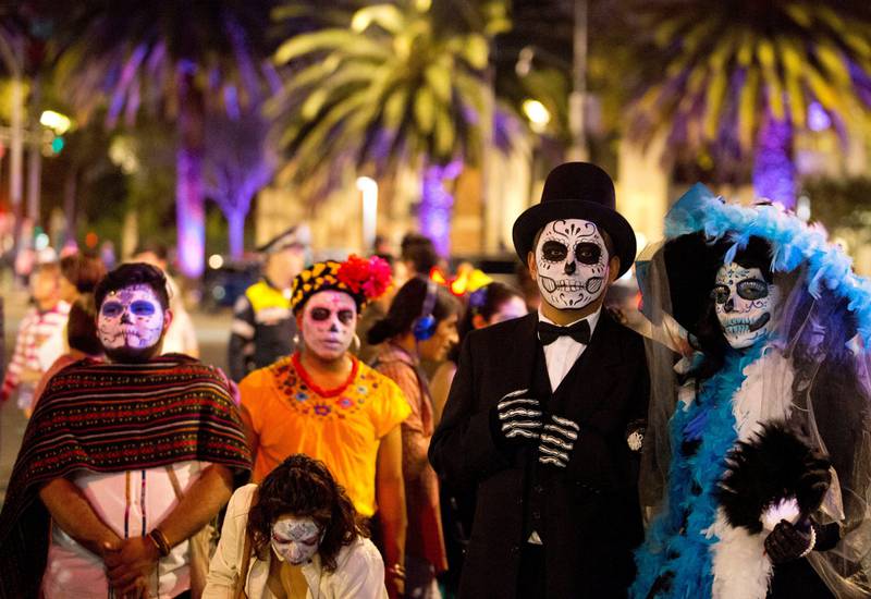 Kvinnen til høyre på bildet er kledd ut som den satiriske figuren «La Catrina», under hodeskalleparaden i Mexico tidligere denne måneden. Nå kommer hun til Norge. FOTO: AP/NTB SCANPIX