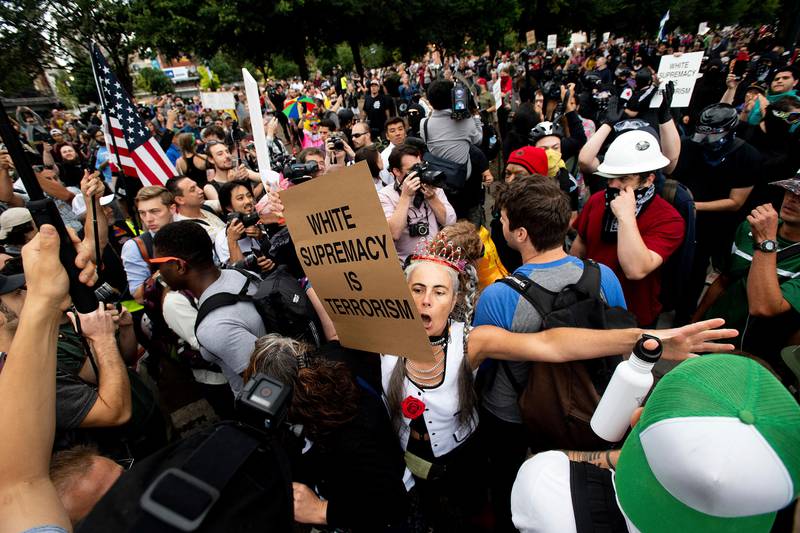 A counter-protester confronts members of the Proud Boys and other right-wing demonstrators during an "End Domestic Terrorism" rally in Portland, Ore., on Saturday, Aug. 17, 2019. Portland Mayor Ted Wheeler said the situation was "potentially dangerous and volatile" but as of early afternoon most of the right-wing groups had left the area via a downtown bridge and police used officers on bikes and in riot gear to keep black clad, helmet and mask-wearing anti-fascist protesters Äî known as antifa Äî from following them.  (AP Photo/Noah Berger)