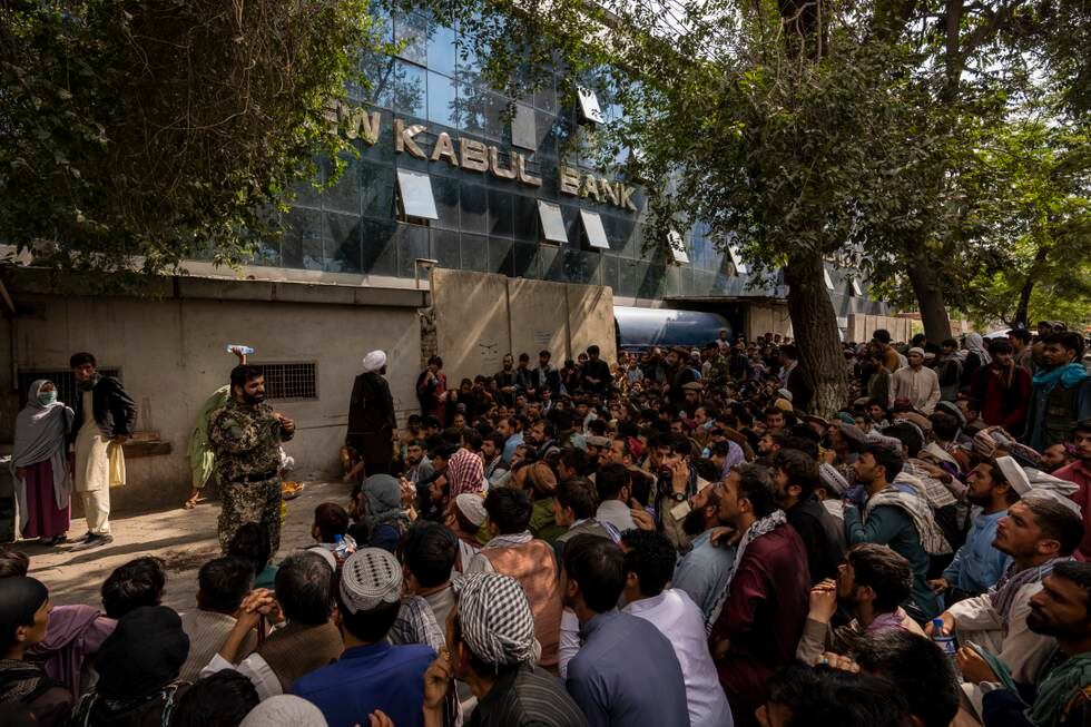 Afghanere venter utenfor en bank i Kabul for å få ta ut penger søndag 12. september.