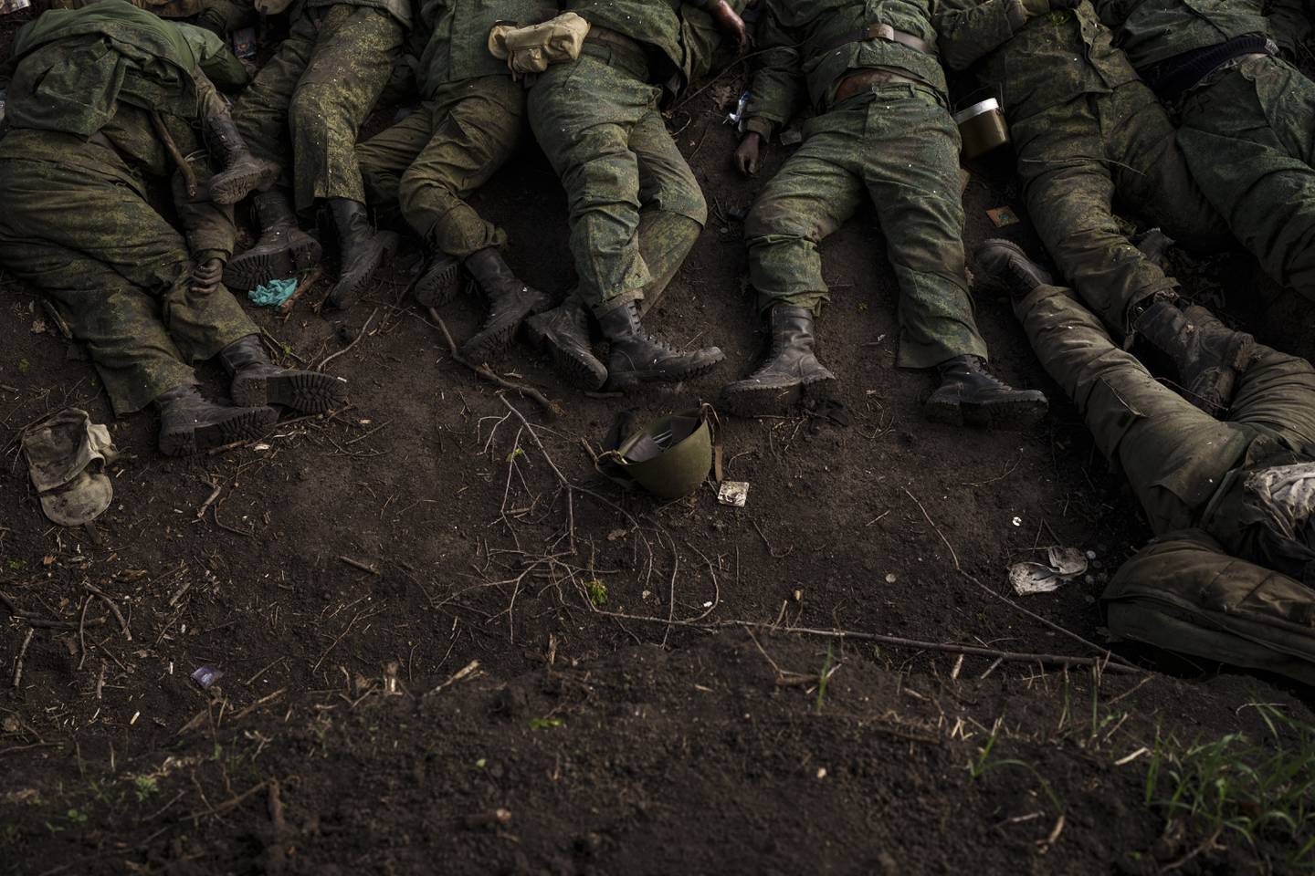 FILE - The bodies of 11 Russian soldiers lie on the ground in the village of Vilkhivka, recently retaken by Ukrainian forces near Kharkiv, Ukraine, Monday, May 9, 2022. More than half a million people have been killed or seriously injured in two years of war in Ukraine, according to Western intelligence estimates -- a human toll not seen in Europe since World War II. (AP Photo/Felipe Dana, File)