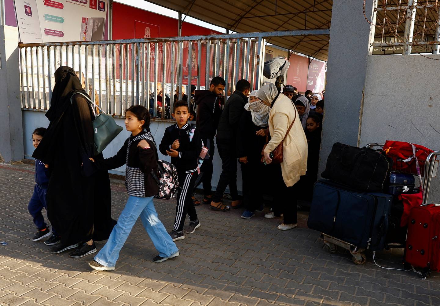 Palestinians with foreign passports arrive at the Rafah border crossing with Egypt, amid the ongoing conflict between Israel and Palestinian Islamist group Hamas, in Rafah in the southern Gaza Strip, November 21, 2023. REUTERS/Ibraheem Abu Mustafa