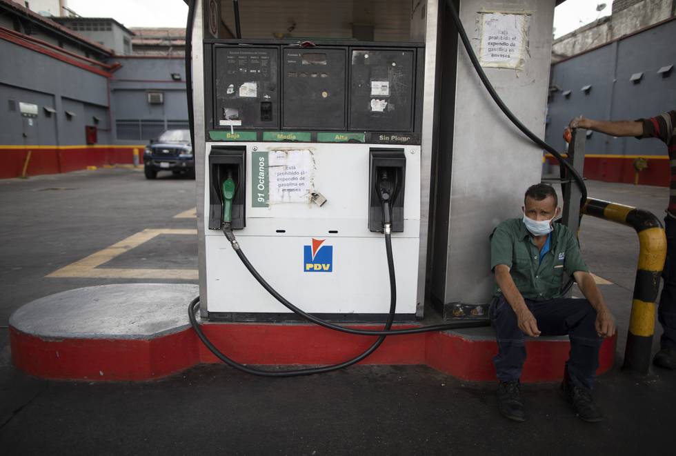 En arbeider ved en stengt bensinpumpe i Caracas i Venezuela i mai 2020.
