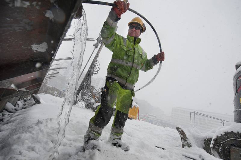 Snøen falt tett over Oslo i dag (26. mars). Pawel Lipinski rengjør rør som skal brukes til forankring av spunten.