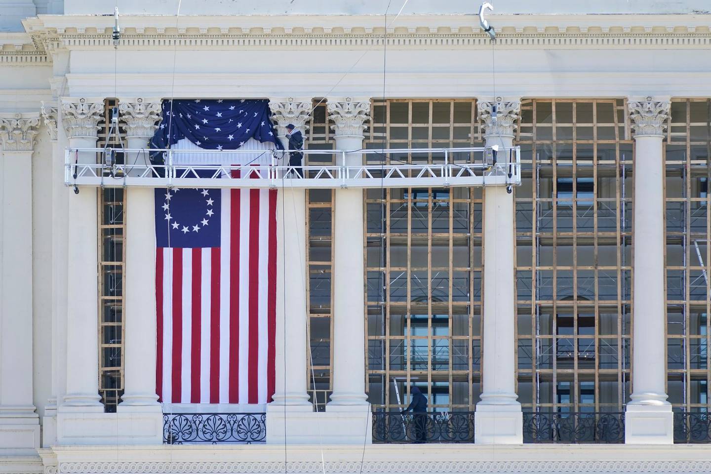 Workers install a flag on the West Front of the U.S. Capitol as preparations take place for President-elect Joe Biden's inauguration, Saturday, Jan. 9, 2021, in Washington. (AP Photo/Patrick Semansky)