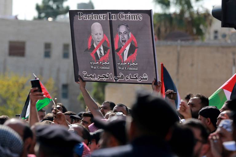 En demonstrant i Jordan holder en plakat hvor Israels statsminister Benjamin Netanyahu og USAs president Joe Biden anklages for krigsforbrytelser.