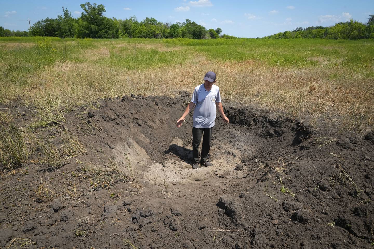 Krigen i Ukraina kan skape en matvarekrisen i verden ettersom ukrainske bønder verken får dyrket eller solgt kornet sitt som vanlig. Her viser kornbonde Serhiy, fram et bombekrater fra en russisk rakett i Ptyche i Donetsk-regionen øst i Ukraina, 12 juni.