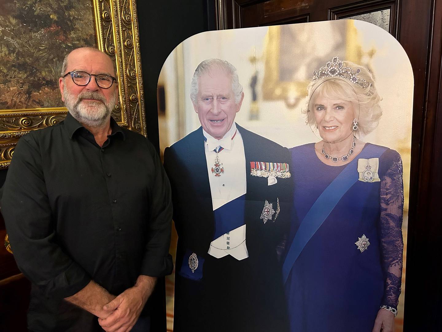 Heller ikke republikktilhengeren Per Hansen slipper unna furoren rundt kroningen, men stiller seg gjerne opp ved siden av plakaten av kong Charles og dronning Camilla på puben i London.