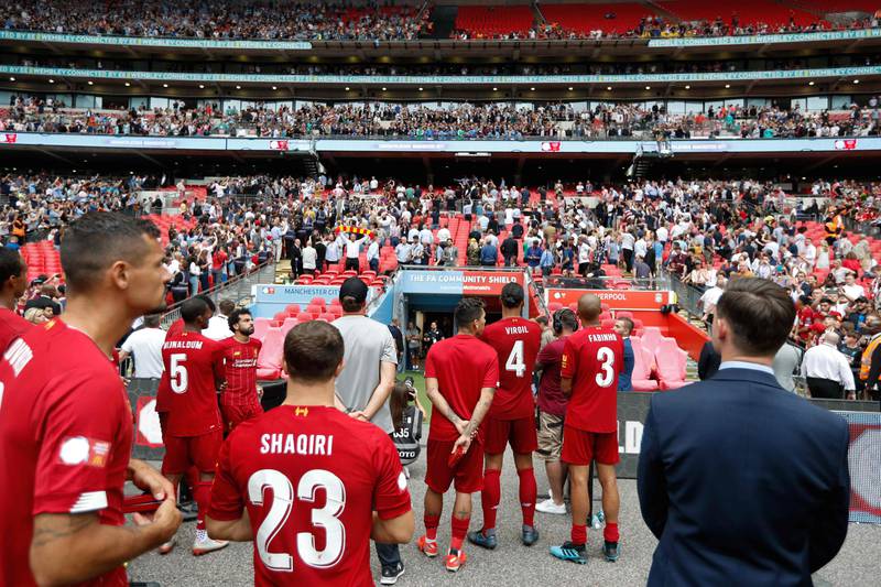 Liverpool players watch as Manchester City players are presented with the trophy after the English FA Community Shield football match between Manchester City and Liverpool at Wembley Stadium in north London on August 4, 2019. (Photo by Adrian DENNIS / AFP) / NOT FOR MARKETING OR ADVERTISING USE / RESTRICTED TO EDITORIAL USE