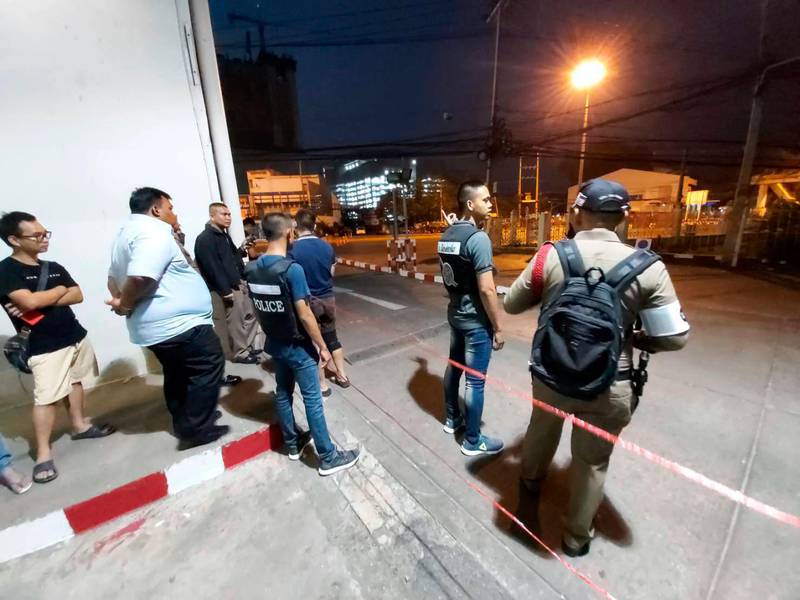 Police and bystanders stand near the scene of a shooting at the Terminal 21 mall, in Korat, Thailand,  Saturday, Feb. 8, 2020. Police in northeastern Thailand said a soldier shot multiple people on Saturday, killing more than 10, and was holed up at a popular shopping mall. (AP Photo)