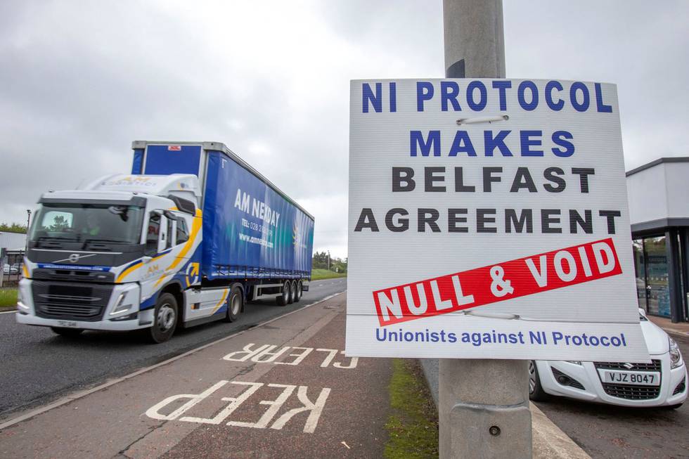 En lastebil som har ankommet med ferge til havnen Larne nord for Belfast i Nord-Irland  passerer en plakat som viser motstand mot den såkalte Nord-Irland-protokollen. Den britiske regjeringen vil gjøre endringer i avtalen med EU, noe EU reagerer sterkt på.