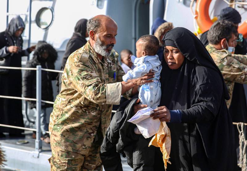 Migrants rescued off the coast of al-Khums, about 120 kilometres east of the capital, disembark off a Libyan coastguard vessel onto the pier in Tripoli's naval base on February 10, 2021. (Photo by - / AFP)