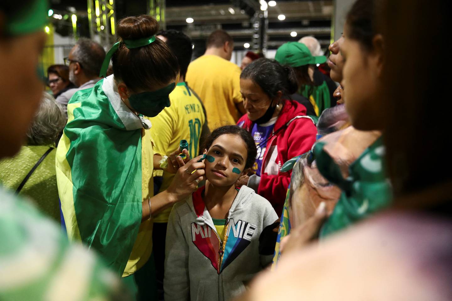 En kvinne får på seg ansiktsmaling for å delta på et valgmøte i regi av Brasils president Jair Bolsonaro.