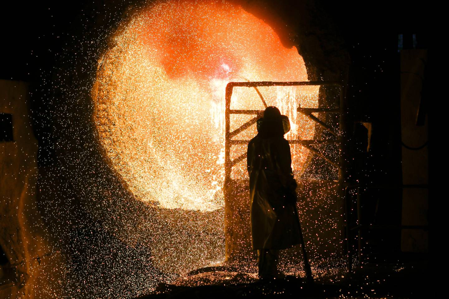 File - In this Tuesday, March 5, 2019, file photo, an employee in protective clothing works with a steel pouring ladle during a guided media tour at the steel producer Salzgitter AG in Salzgitter. The German economy shrank by 0.1 percent in the second quarter from the previous quarter as global trade conflicts and troubles in the auto industry weighed on Europe's largest economy. (AP Photo/Markus Schreiber)