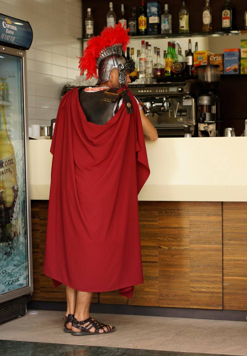 A man wearing an ancient Roman centuriun costume stands at a bar counter at a cafe' in Rome, Tuesday, May 23, 2017. (AP Photo/Andrew Medichini)