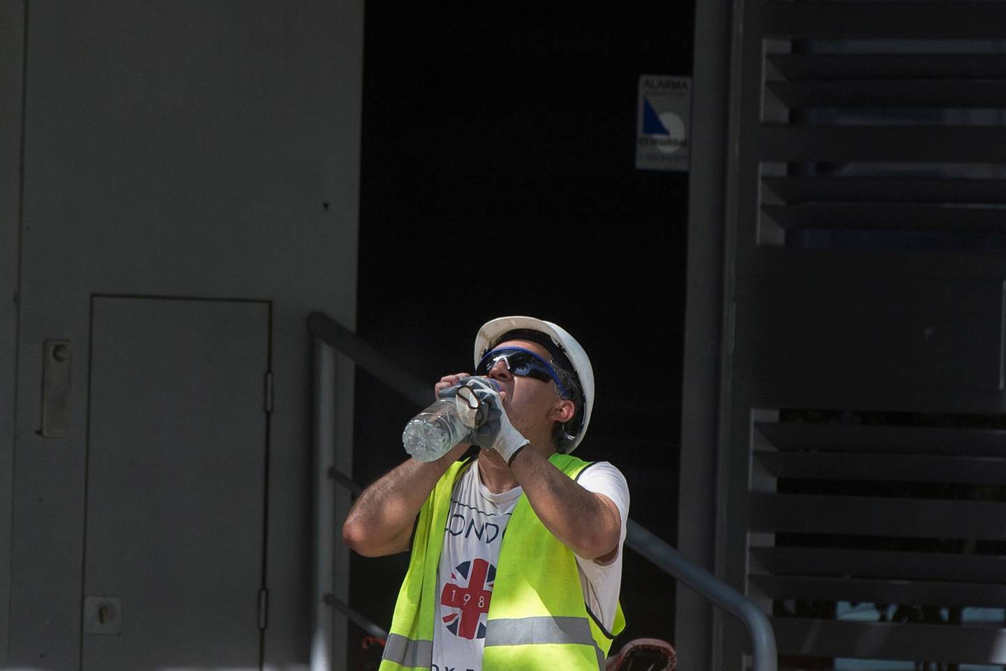 A worker stops to drink from a bottle of water in Madrid, Spain, Thursday, July 25, 2019. Points across Europe are bracing for record temperatures Thursday as the second heat wave this summer bakes the continent. Climate scientists warn this could become the new normal in many parts of the world. But temperate Europe, where air conditioning is rare and isn't equipped for the temperatures frying the region this week. (AP Photo/Paul White)