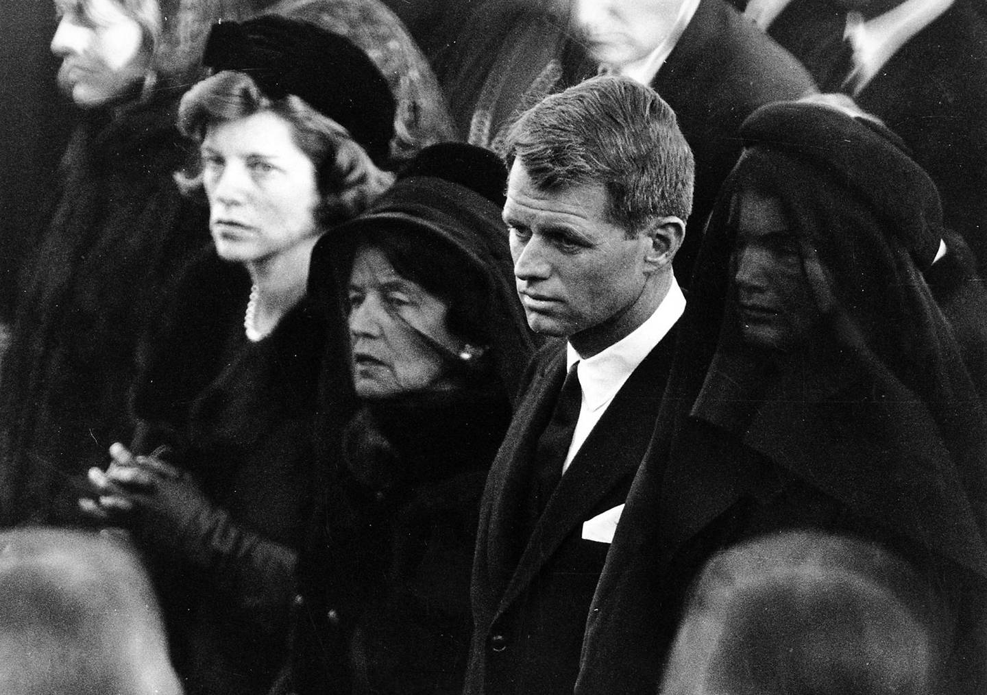 I John F. Kennedys begravelse i november 1963 står Robert Kennedy sammen med moren Rose på den ene siden og enken Jaqueline på den andre. 