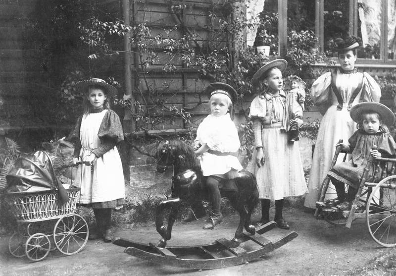 Bedremanns barn leker i St. Olavs gate 25, 1896. Til høyre en rullestol.