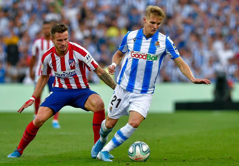 Real Sociedad's Norwegian midfielder Martin Odegaard (R) vies with Atletico Madrid's midfielder Saul Niguez during the Spanish league football match Real Sociedad against Club Atletico de Madrid at The Anoeta Stadium in San Sebastian on September 14, 2019. (Photo by ANDER GILLENEA / AFP)