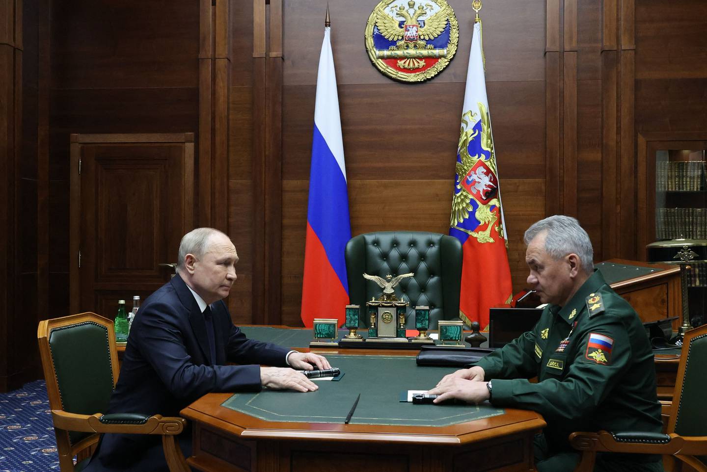 In this pool photograph distributed by Russia's state agency Sputnik, Russian President Vladimir Putin and Defence Minister Sergei Shoigu hold talks after an expanded meeting of the Russian Defence Ministry Board at the National Defence Control Centre in Moscow on December 19, 2023. (Photo by Mikhail KLIMENTYEV / POOL / AFP)