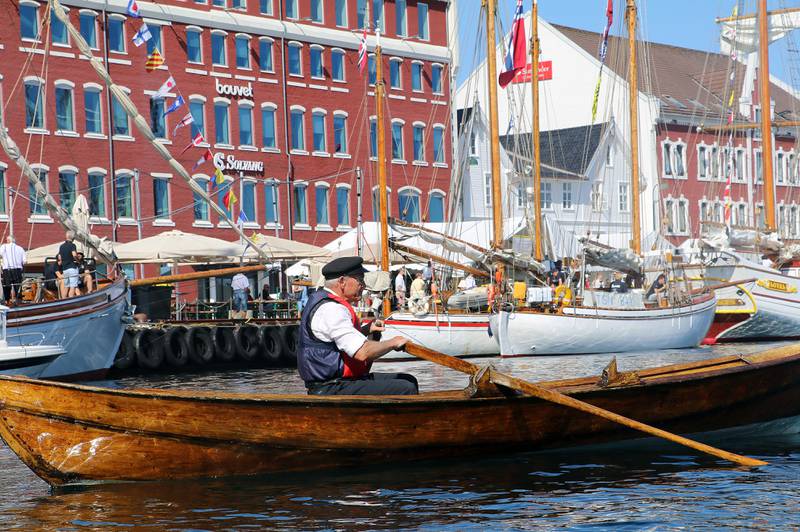 Anstendig antrukket roer med blankpusset båt på vei innerst i Vågen i Stavanger.