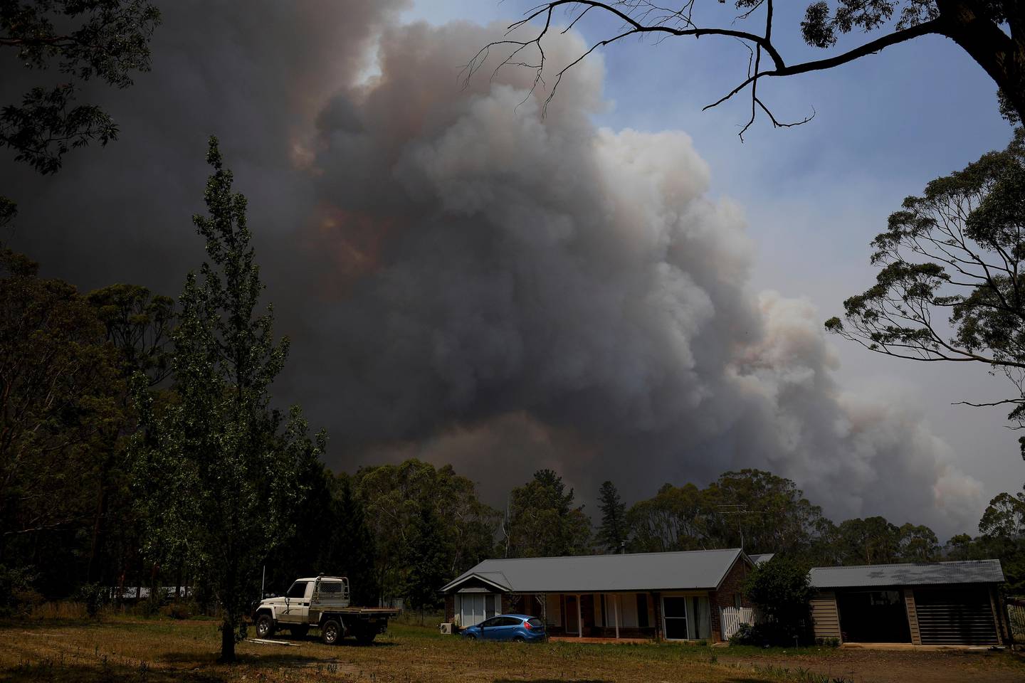A home stands as smoke from the Grose Valley fire rises in the distance in Bilpin, west of Sydney, Saturday, Dec. 21, 2019. Australias most populous state has been paralyzed by catastrophic fire conditions Saturday amid souring temperatures as wildfires also ravaged the countrys southeast. (AAP Image/Dan Himbrechts) NO ARCHIVING