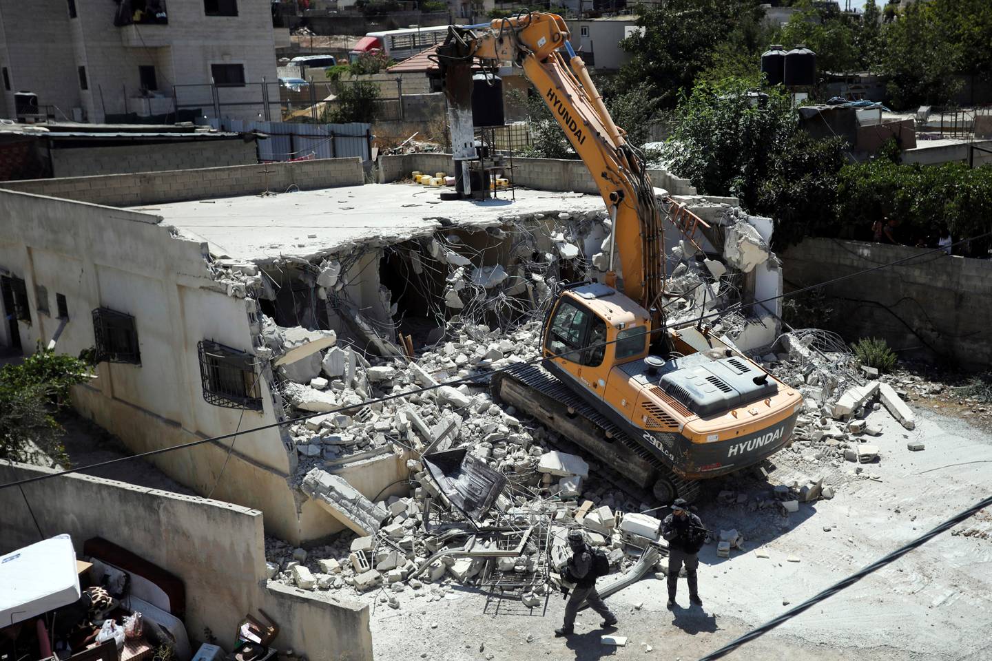 FILE - In this Aug. 21, 2019 file photo, Israeli authorities demolish a Palestinian owned house in east Jerusalem. A rights group says Israeli authorities have demolished at least 140 Palestinian homes in east Jerusalem this year, the highest annual number since it began keeping records in 2004. The demolition of homes built without permits comes amid a major increase in Jewish settlement activity both in east Jerusalem and in the occupied West Bank since U.S. President Donald Trump took office.(AP Photo/Mahmoud Illean, File)