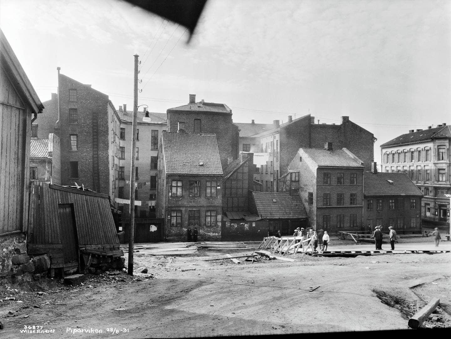 Den gamle bebyggelsen i Pipervika fotografert 28. august 1931, bare få dager før Rådhusets grunnsteinsnedleggelse. Forberedelsen er i gang.