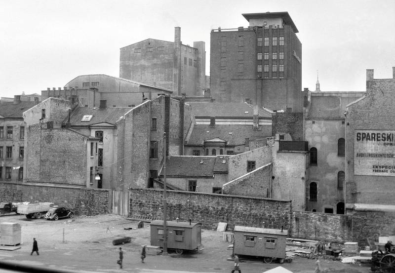 Arbeidsbrakker på Arbeidersamfundets plass med rester av Tukthusmuren bak i 1952. Midt i bildet Folketeaterbygningen.