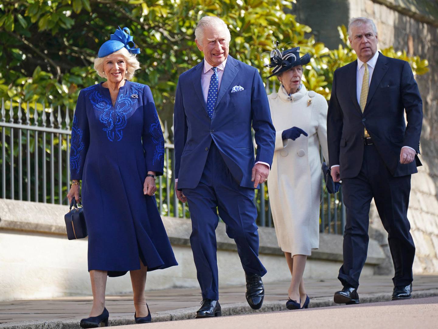 Fire kongelige går på en vei. Kongen og dronningen er kledd i blått.