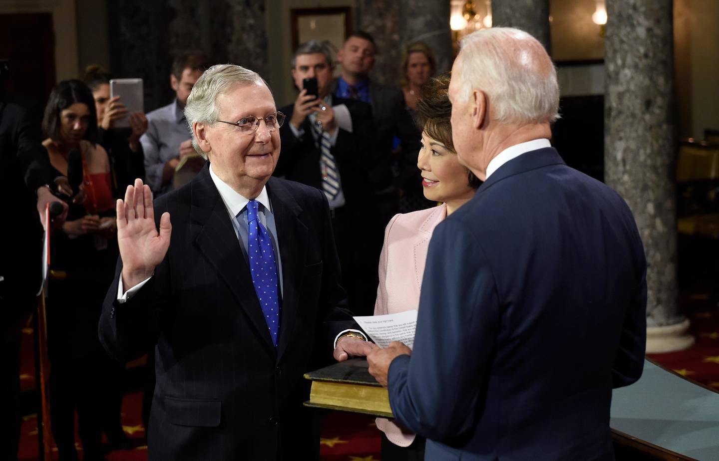 Vice President Joe Biden, right, administers the Senate oath to Senate Majority Leader Mitch McConnell of Ky. during a ceremonial re-enactment swearing-in ceremony, Tuesday, Jan. 6, 2015, in the Old Senate Chamber on Capitol Hill in Washington. McConnell's wife, former Labor Secretary Elaine Chao is at center. (AP Photo/Susan Walsh)