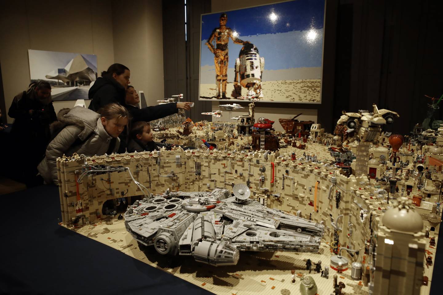 Children watch a Lego sculpture depicting a scene of the movie Star Wars during an exhibition « Ciné en Briques » (Cine Bricks), in Versailles, Wednesday, Dec. 18, 2019. The exhibition whose theme is cinema is created with Lego bricks and runs until Jan. 25. (AP Photo/Christophe Ena)