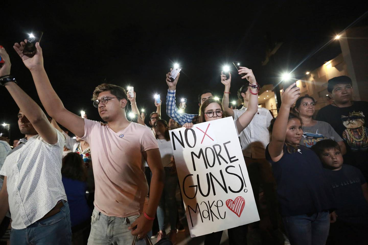 People gather in Juarez, Mexico, Saturday, Aug. 3, 2019, in a vigil for the 3 Mexican nationals who were killed in an El Paso shopping-complex shooting. Twenty people were killed and more than two dozen injured in a shooting Saturday in a busy shopping area in the Texas border town of El Paso, the stateÄôs governor said. (AP Photo/Christian Chavez)