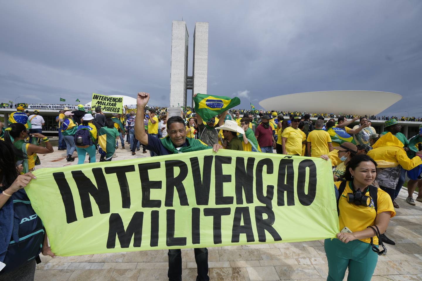 Flere demonstranter gikk rundt med banner hvor de ber om en militær intervensjon for å gjeninnsette den høyreradikale Jair Bolsonaro ved makten. Foto: Eraldo Peres / AP / NTB