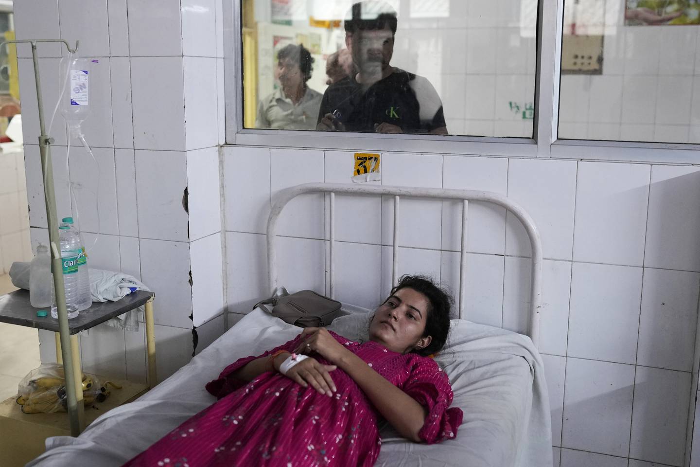 En ung indisk kvinne ligger i en sykeseng med heteslag.