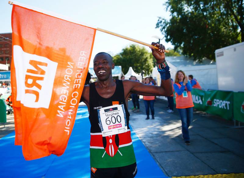 Stephen Mbugua løp med flagget til Flyktningehjelpen.  FOTO: HEIKO JUNGE/NTB SCANPIX