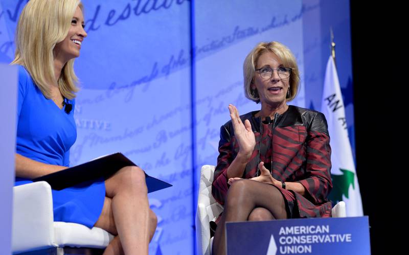 (FILES) In this file photo Education Secretary Betsy DeVos (R) makes remarks as moderator Kayleigh McEnany(L) listens during a discussion at the Conservative Political Action Conference (CPAC) at National Harbor, Maryland, February 23, 2017. - Kayleigh McEnany, a former Fox News figure who is fiercely loyal to President Donald Trump, took over April 15, 2020 as his new press secretary, entering the high-profile job at a time of turmoil in White House relations with the press. McEnany, 31, made the formal announcement a week after her predecessor Stephanie Grisham stepped down. (Photo by Mike Theiler / AFP)