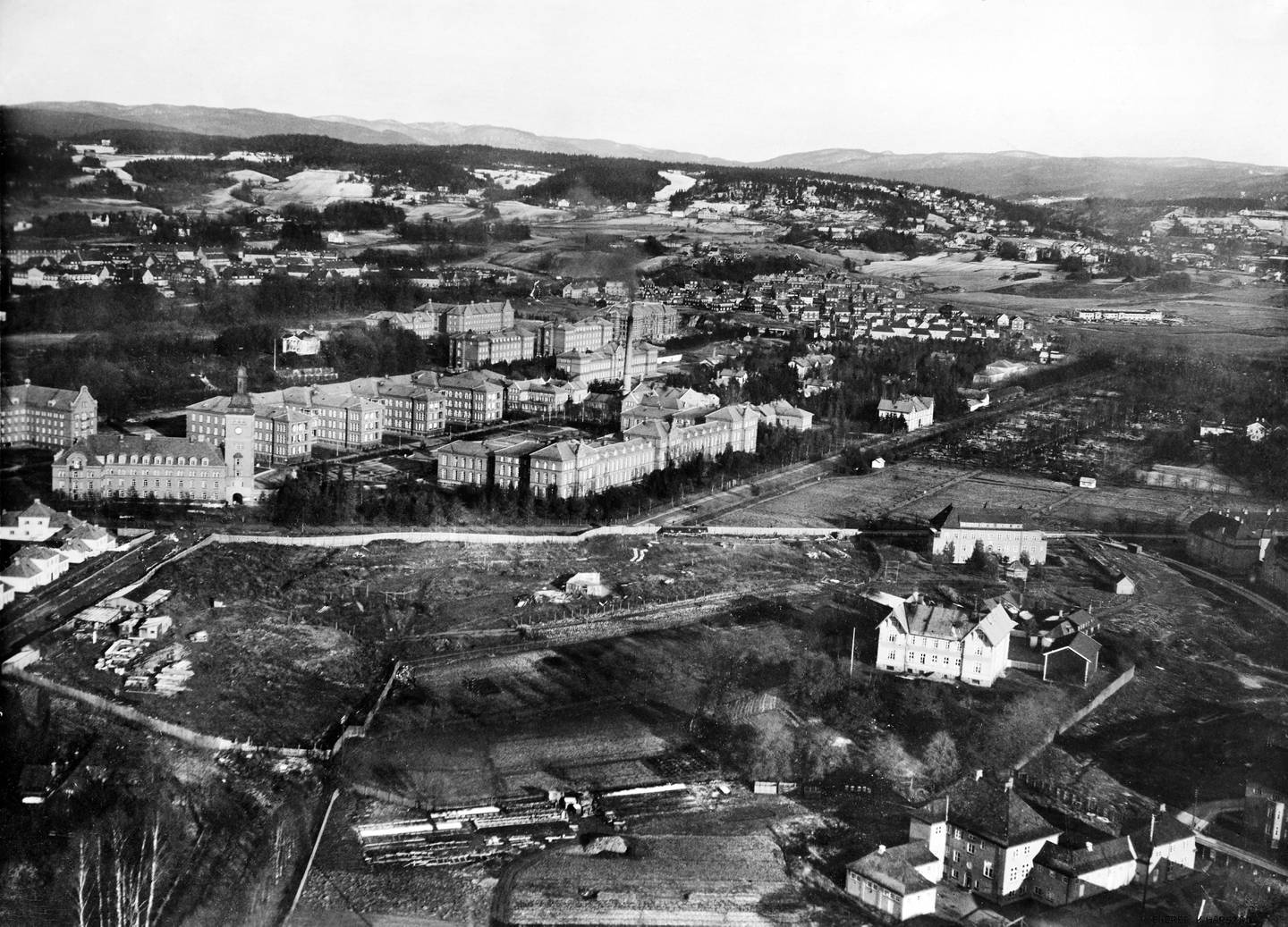 Flyfoto over Lindern skole (til høyre i bildet) i 1924. I bakgrunnen Ullevål sykehus, Tåsen hageby og Ullevål hageby.