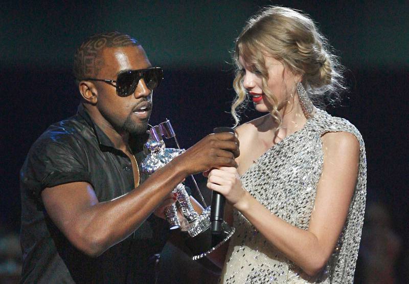 FILE - In this Sept. 13, 2009 file photo, singer Kanye West takes the microphone from singer Taylor Swift as she accepts the "Best Female Video" award during the MTV Video Music Awards in New York.  (AP Photo/Jason DeCrow, file)