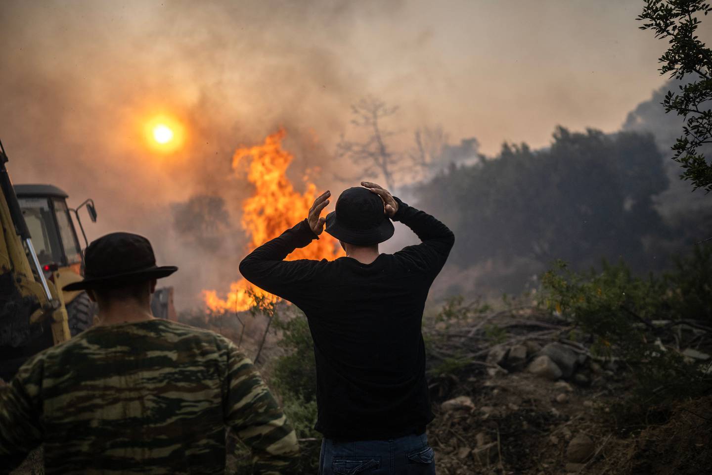 En mann reagerer mens en brann brenner inn i landsbyen Gennadi på den greske øya Rhodos, 25. juli.