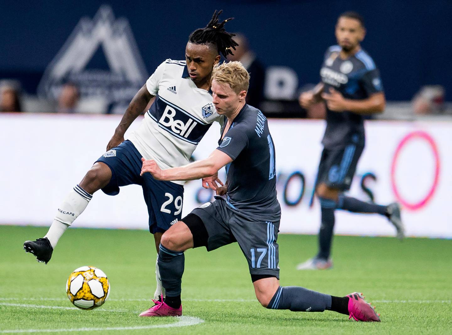 Vancouver Whitecaps forward Yordi Reyna (29) fights for control of the ball with New York City FC Gary Mackay-Steven during the second half of MLS soccer match in Vancouver, British Columbia, Saturday, Aug. 31, 2019. (Jonathan Hayward/The Canadian Press via AP)