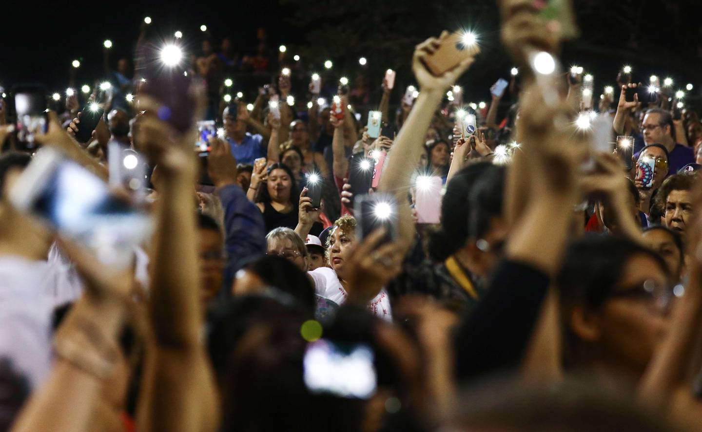 EL PASO, TEXAS - AUGUST 04: People hold up their phones in lieu of candles at an interfaith vigil for victims of a mass shooting, which left at least 20 people dead, on August 4, 2019 in El Paso, Texas. A 21-year-old male suspect was taken into custody in the city which sits along the U.S.-Mexico border. At least 26 people were wounded.   Mario Tama/Getty Images/AFP
== FOR NEWSPAPERS, INTERNET, TELCOS & TELEVISION USE ONLY ==