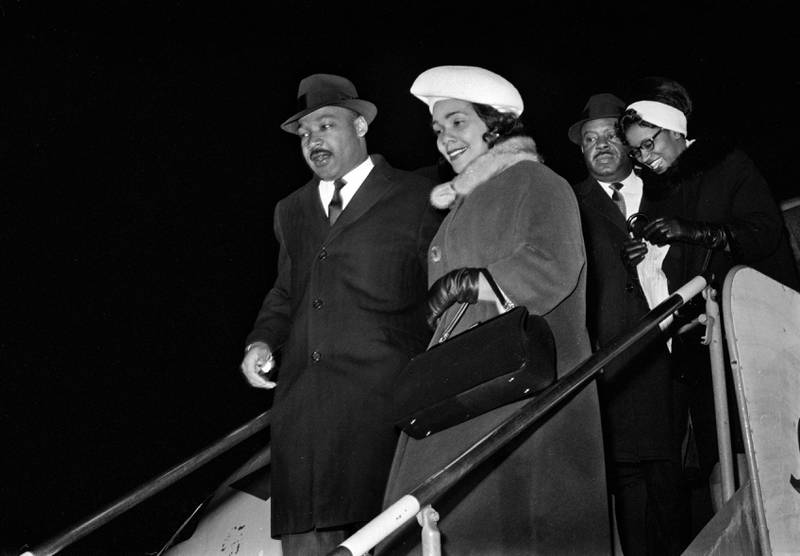Martin Luther King og hans kone Coretta King på vei ned flytrappa, etter å ha landet på Fornebu i desember 1964.