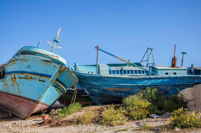 Utrangeserte libyske fiskebåtar er populære blant menneskesmuglarane som sender reisande over Middelhavet. Desse har stranda for godt på stranda i Portoalto, heilt sør på Sicilia. FOTO: EDRLEND BERGE