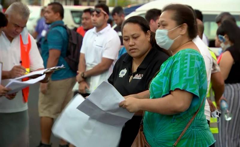 In this image from video,  people gather outside a health emergency operation center Thursday, Dec. 5, 2019, in Apia, Samoa.  Samoas main streets were eerily quiet on Thursday, Dec. 5, 2019, as the government stepped up efforts to curb a measles epidemic that has killed 62 people. (TVNZ via AP)