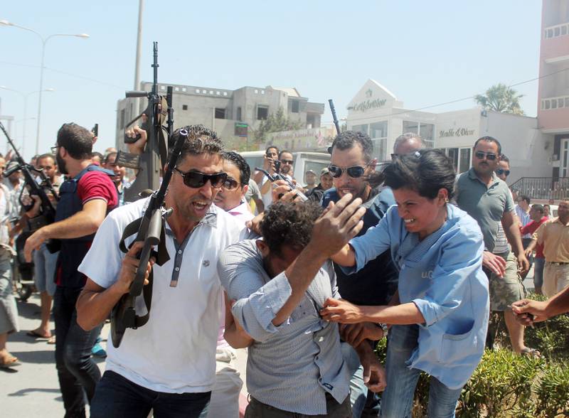 Politiet forsøkt å få kontroll på folkemengden mens de tok fatt i en mann mistenkt for å være involvert i angrepet på to hoteller i Sousse, Tunisia. FOTO: AMINE BEN AZIZA/NTB SCANPIX