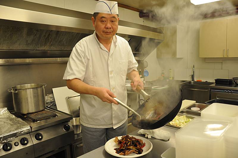 Wei Hua Wang lager pepperbiff med woken på kjøkkenet. Foto: Tore Bruland