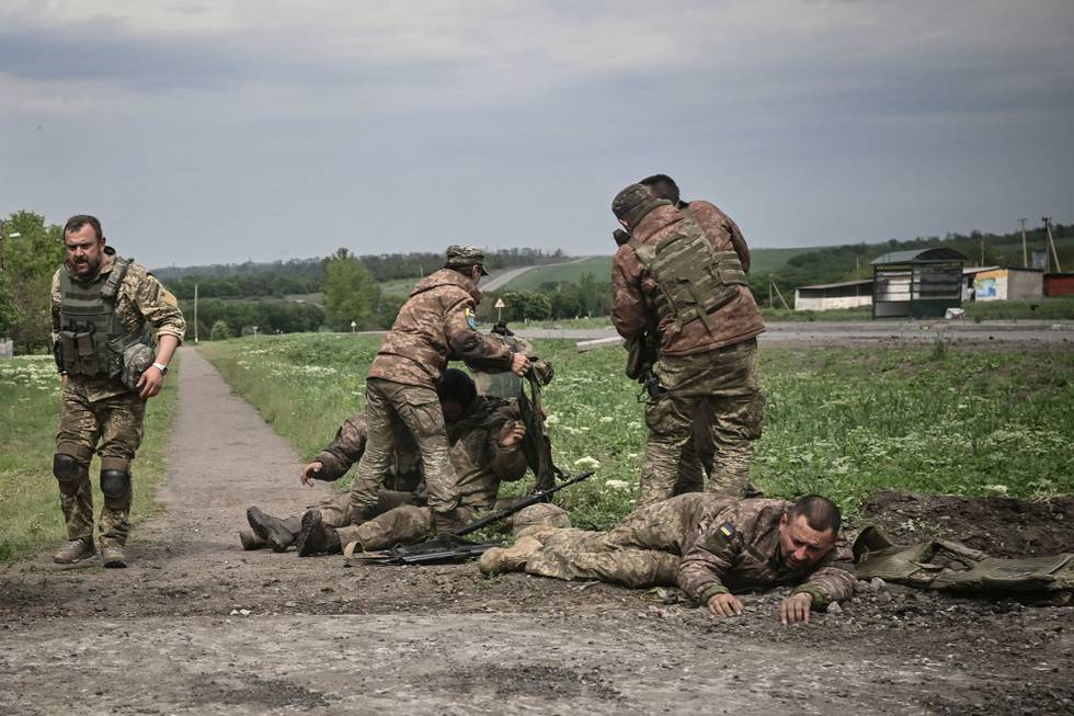 Ukraina-krigen har vart i 100 dager fredag denne uka. Her er ukrainske soldater som hjelper hverandre like ved fronten i Donbas 21. mai.