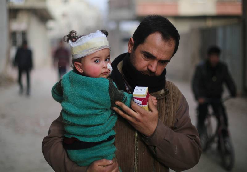 En syrisk mann bærer et skadet barn på armen i den opprørskontrollerte delen av Øst-Ghouta utenfor Damaskus i Syria. Regimestyrker utsatte byen for massive luftangrep sist uke og flere hundre sivile ble rammet, også mange barn.