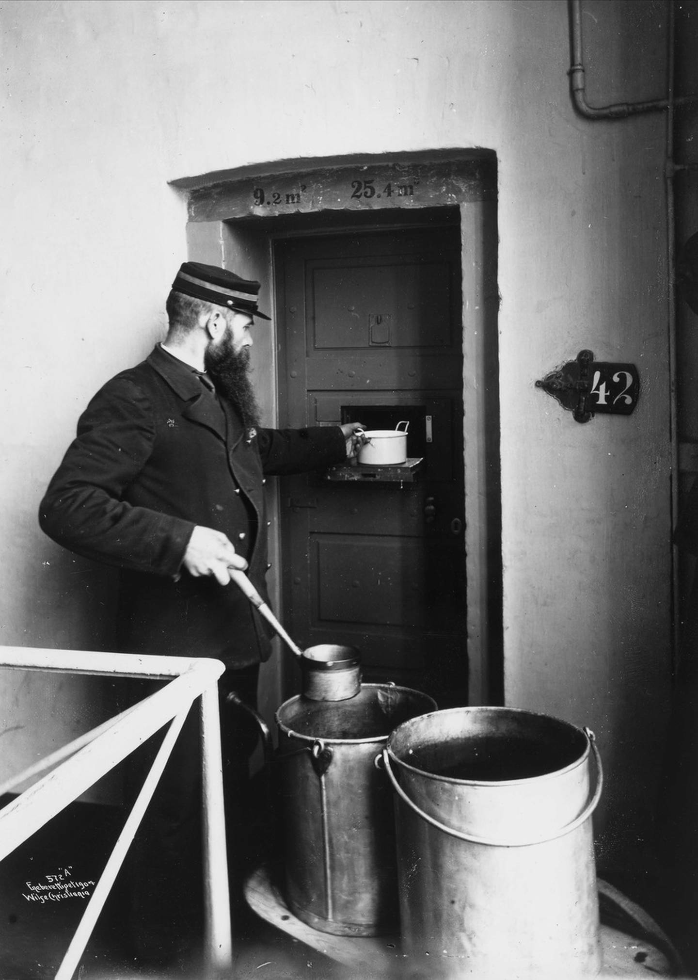 Matutdeling gjennom luke i døra på botsfengslet i 1904.
